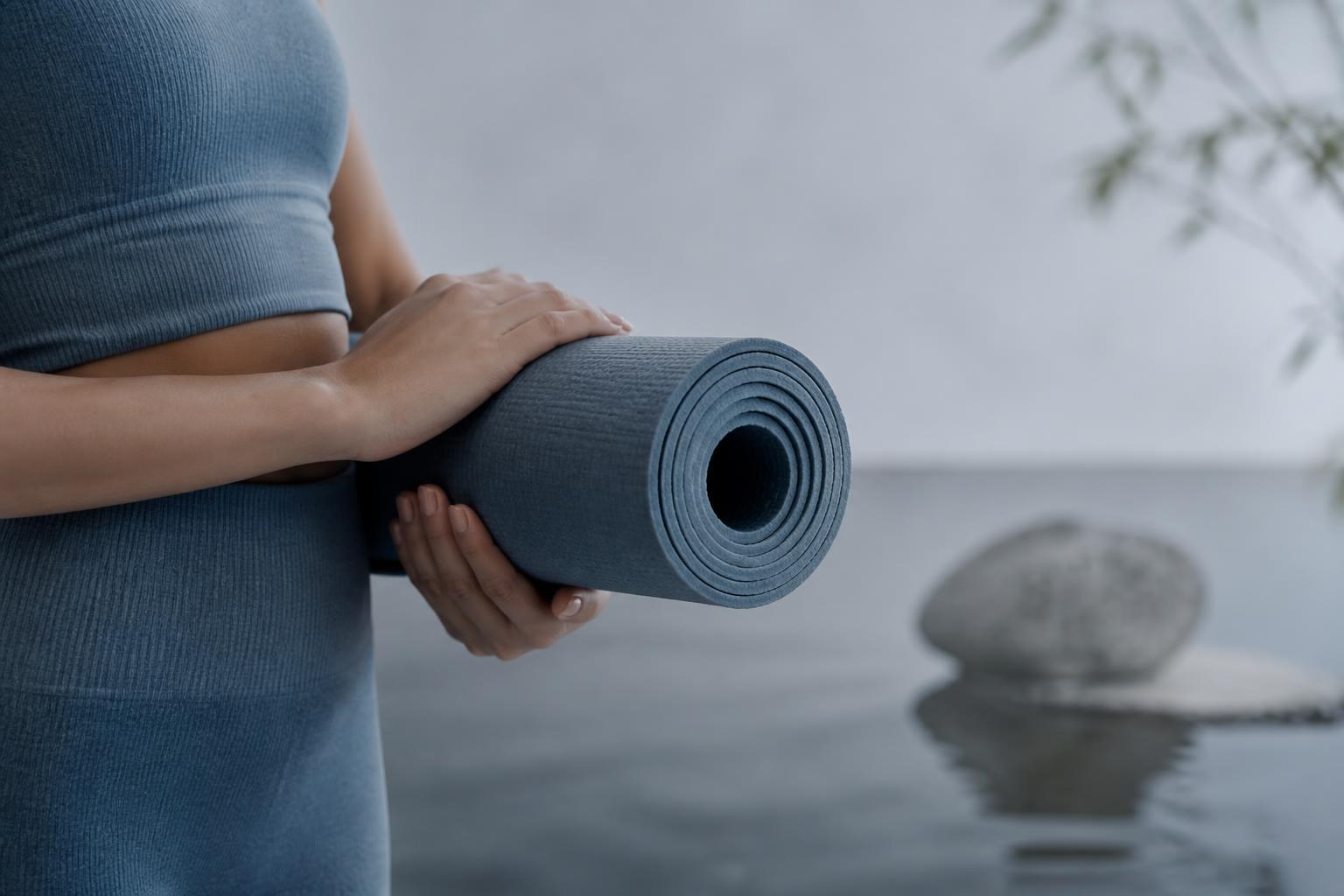 Hands holding a yoga mat